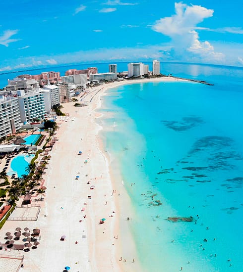 Fotografía panorámica de la arena blanca y el mar turquesa en una de las playas públicas de Cancún para la guía de la Revista YO CANCÚN, Quintana Roo.