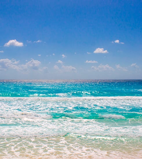 Fotografía panorámica de la arena blanca y el mar turquesa en una de las playas públicas de Cancún para la guía de la Revista YO CANCÚN, Quintana Roo.